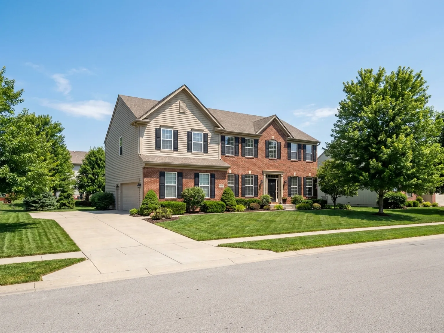 Brick-front two-story suburban home with a green lawn in an Olathe, KS neighborhood