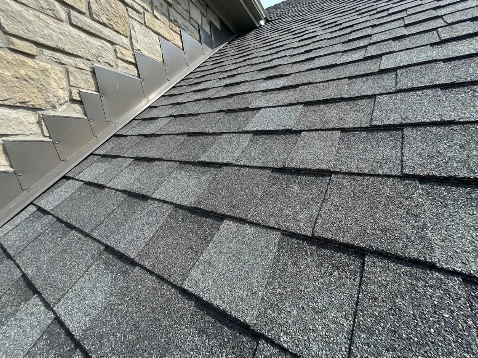 Close-up detail of Class 4 impact-resistant architectural shingles and metal flashing on a Kansas City roof